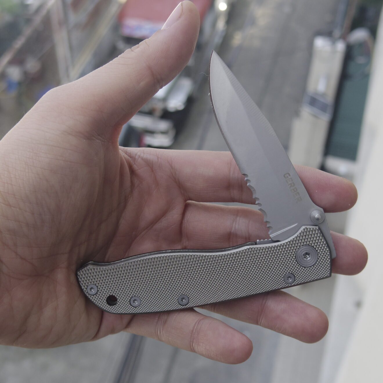 Gerber Air Ranger knife open in hand showing serrations, pivot and handle texture